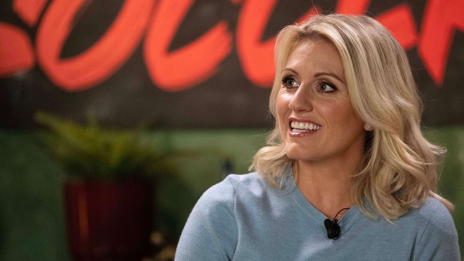 Sports broadcaster Rebecca Lowe smiling while speaking during a television studio segment
