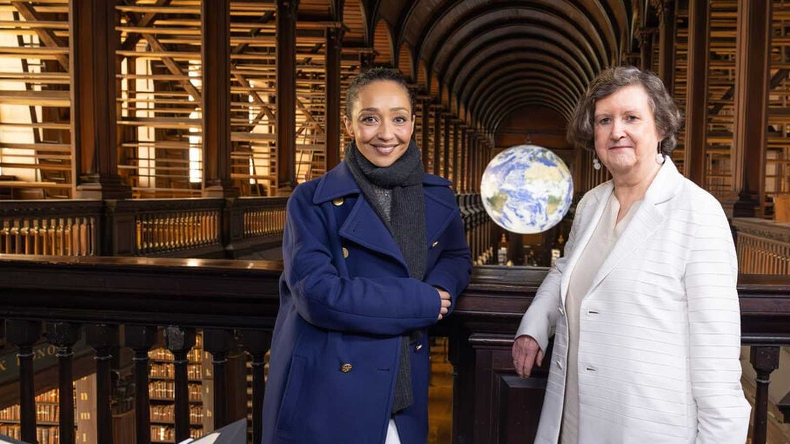 Ruth Negga and a colleague standing inside the historic Trinity College Dublin library