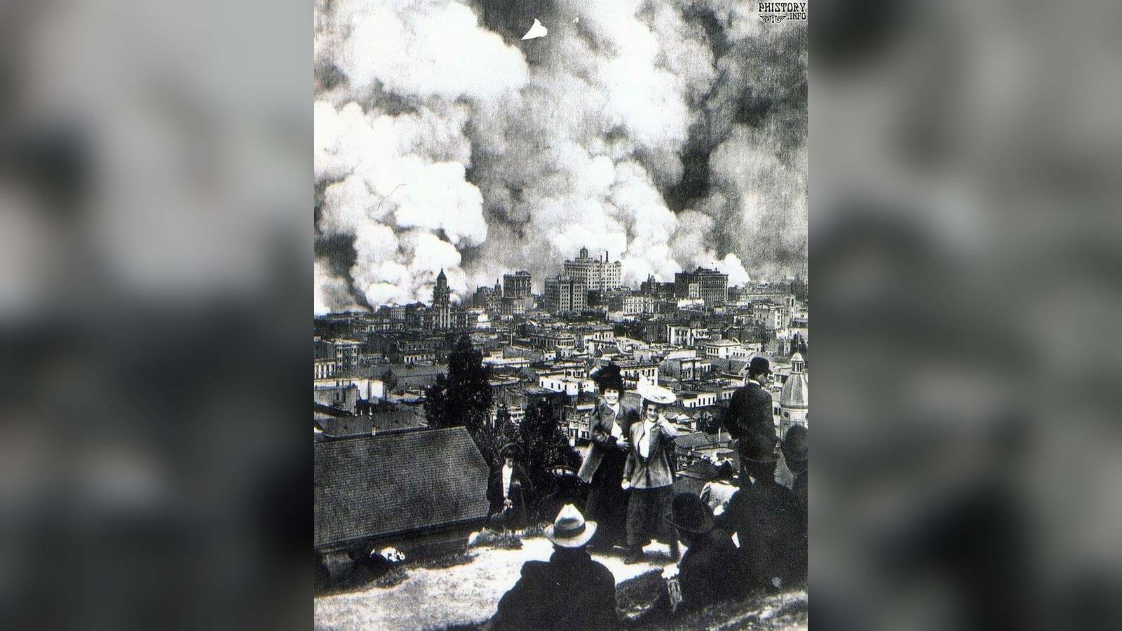 A group of women posing for a photograph with the burning city of San Francisco in the background du