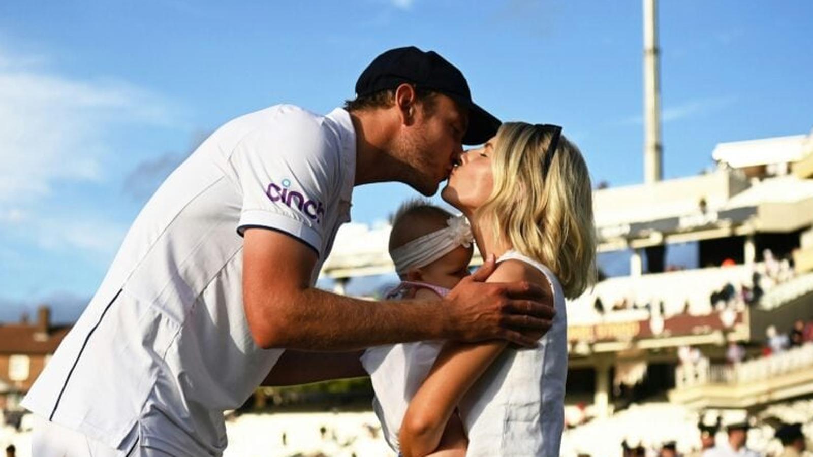 Stuart Broad kissing wife Mollie King while holding their baby on a cricket pitch
