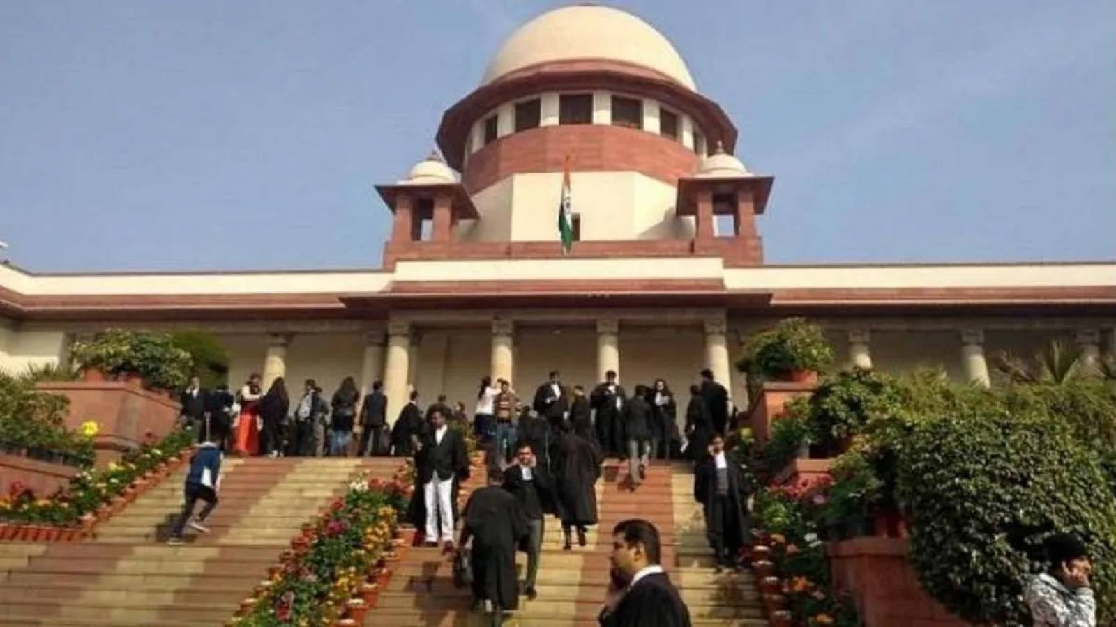 The Supreme Court of India building with lawyers walking on the front steps