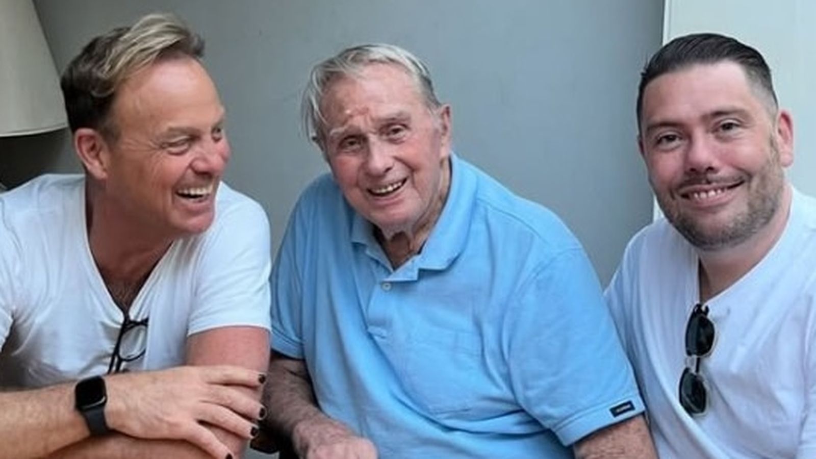 Australian actor Terence Donovan smiling while sitting between his two sons Jason and Josh