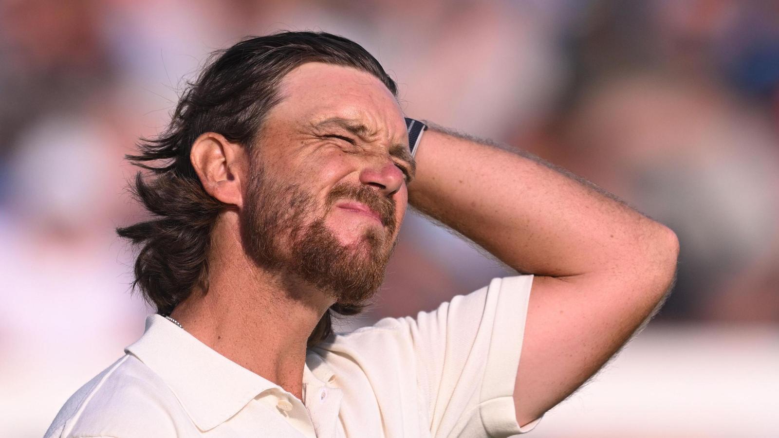 Professional golfer Tommy Fleetwood looking stressed with hand on head during tournament