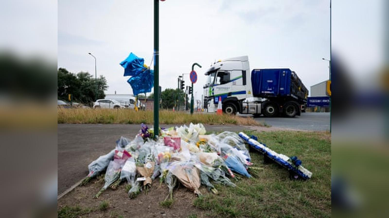 A collection of floral tributes and blue balloons placed at the A66 crash site