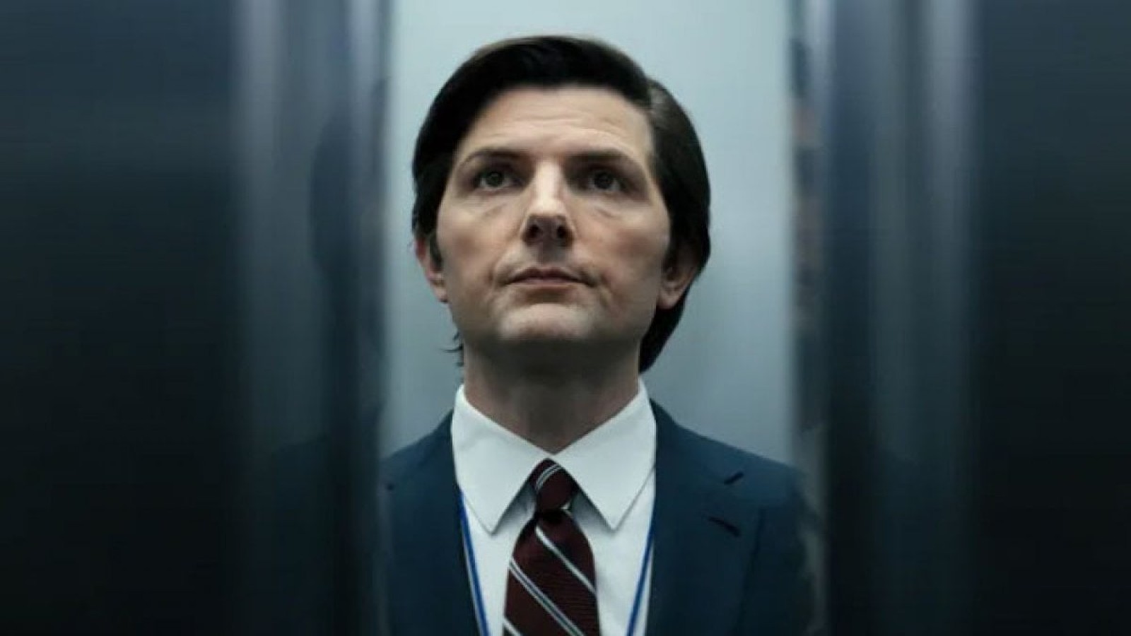 Actor Adam Scott wearing a suit and tie in a scene from Severance