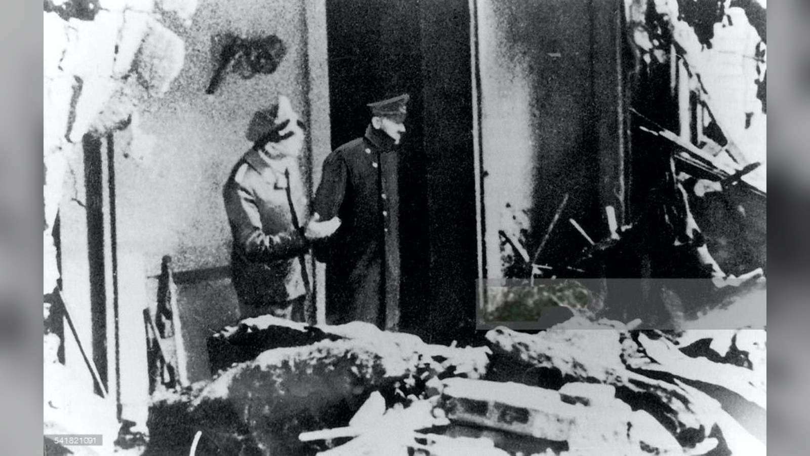 Black and white photograph of Adolf Hitler and Julius Schaub inspecting the ruined grounds of the Re