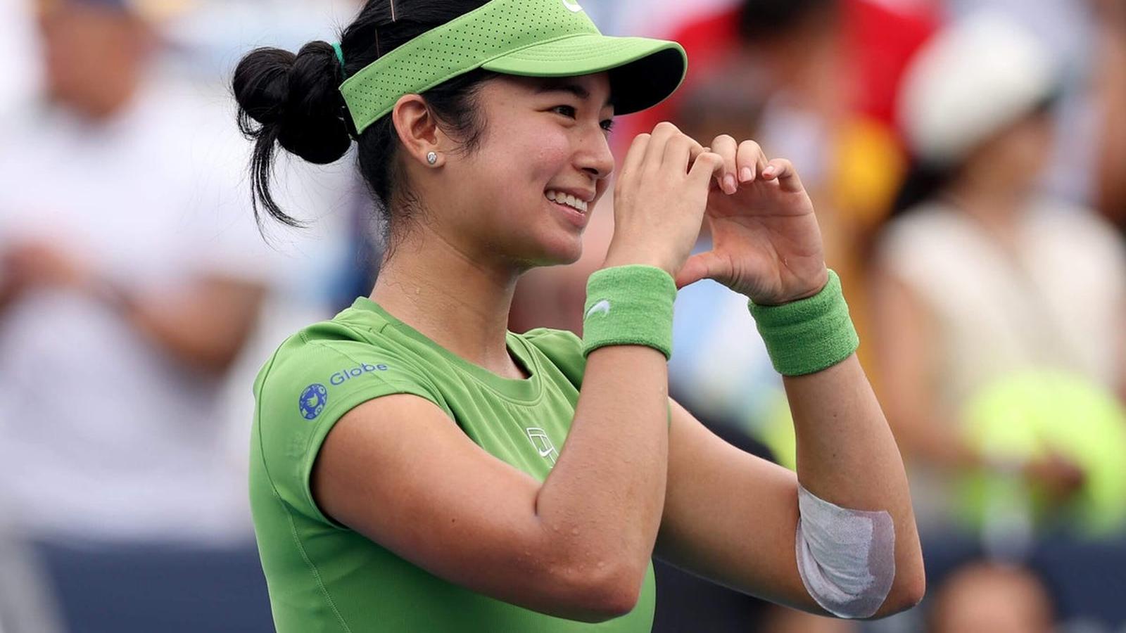 Alexandra Eala smiling and making a heart gesture with her hands on court