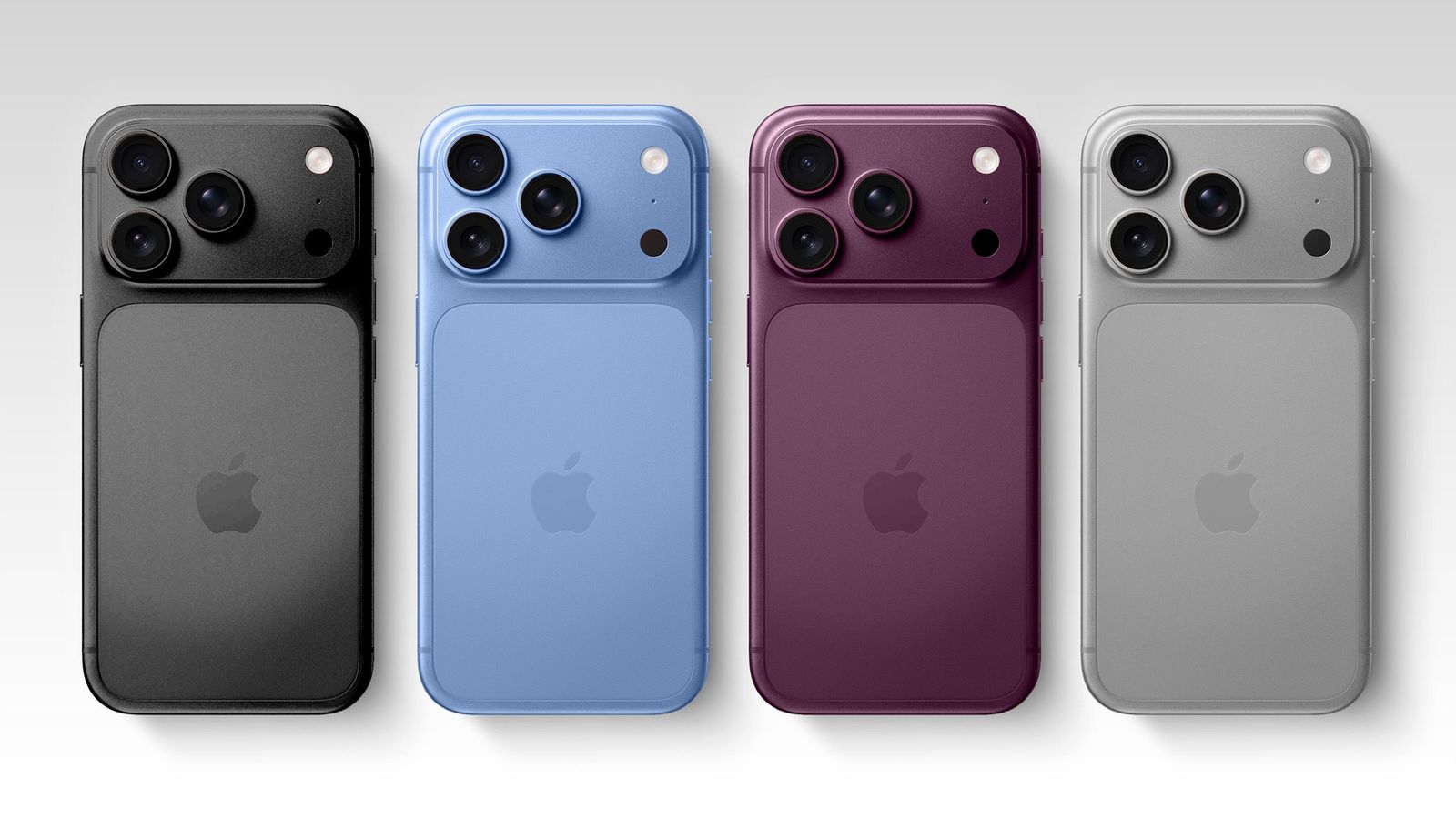 Four different colored smartphones with triple camera arrays arranged in a row