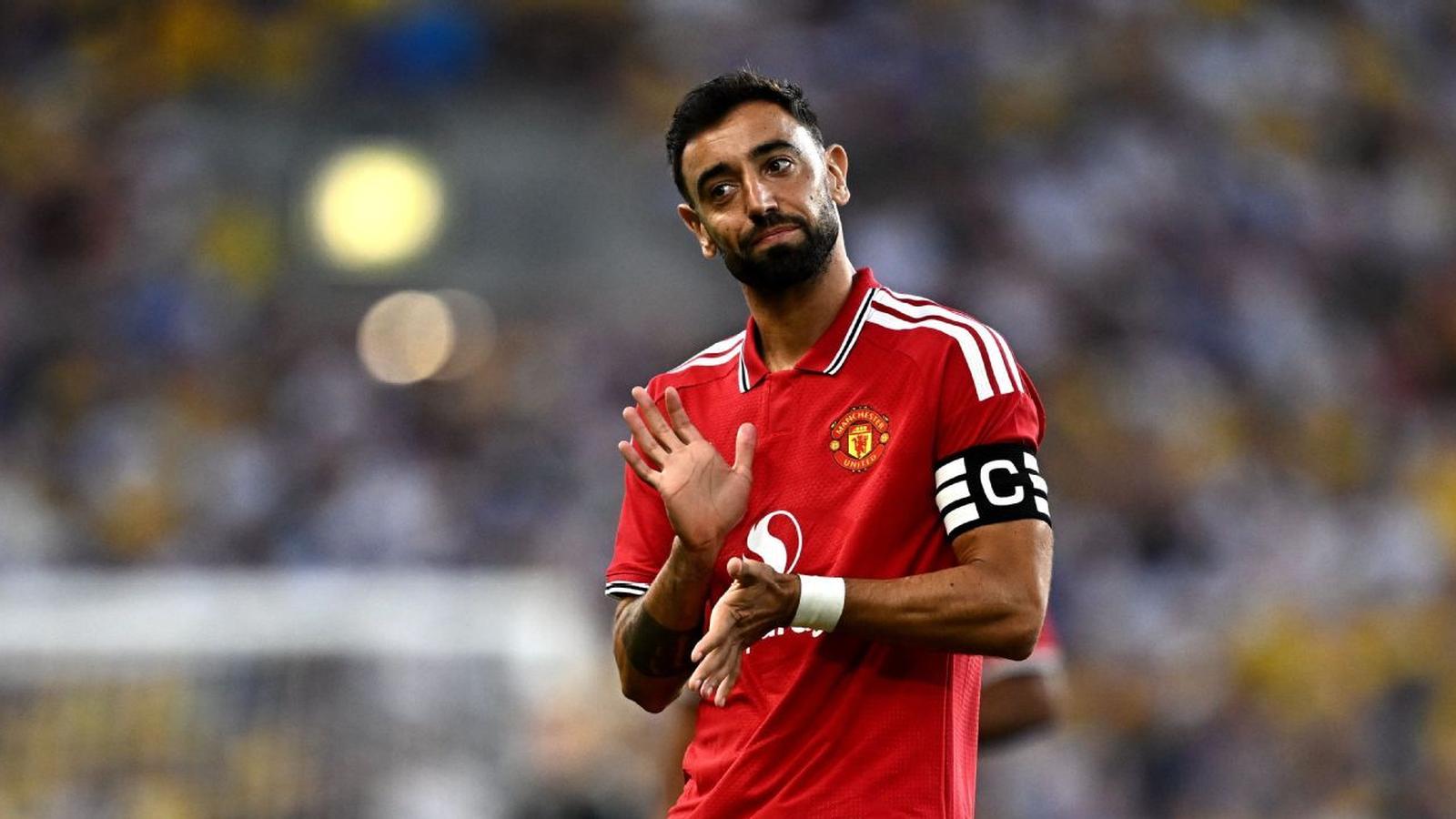 Manchester United captain Bruno Fernandes clapping while wearing the red home kit on pitch