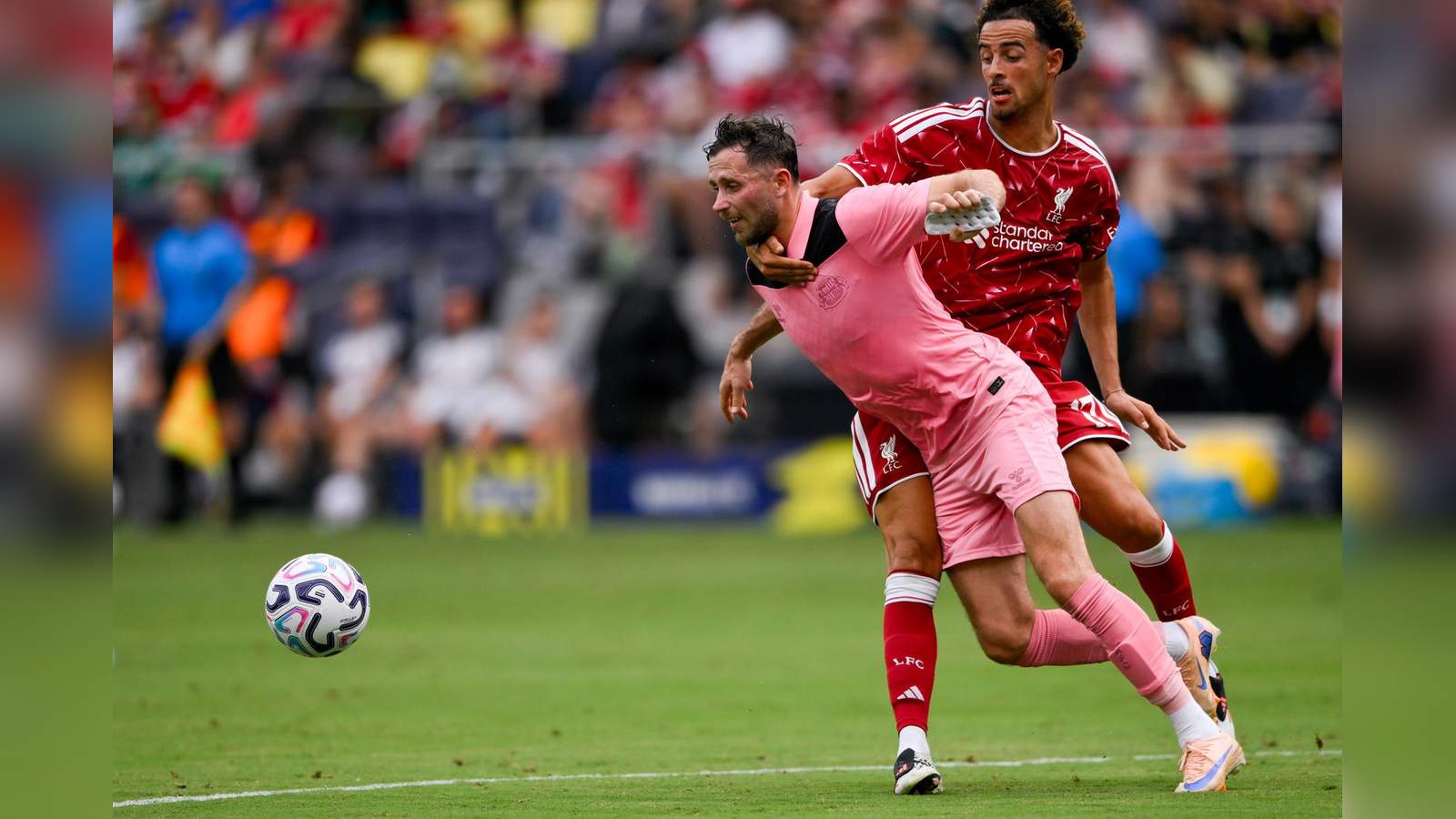 Curtis Jones in a Liverpool kit challenging for the ball during a match