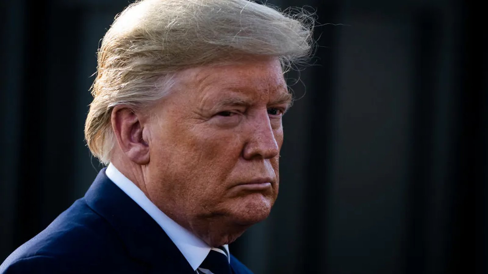 Close up portrait of Donald Trump looking serious against a dark background