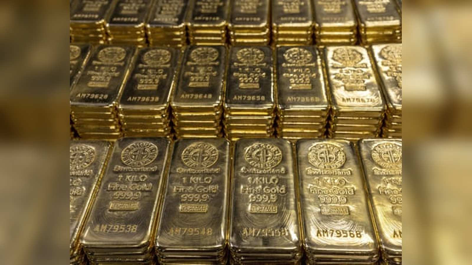 Rows of shiny one kilogram fine gold bars stacked in a secure vault