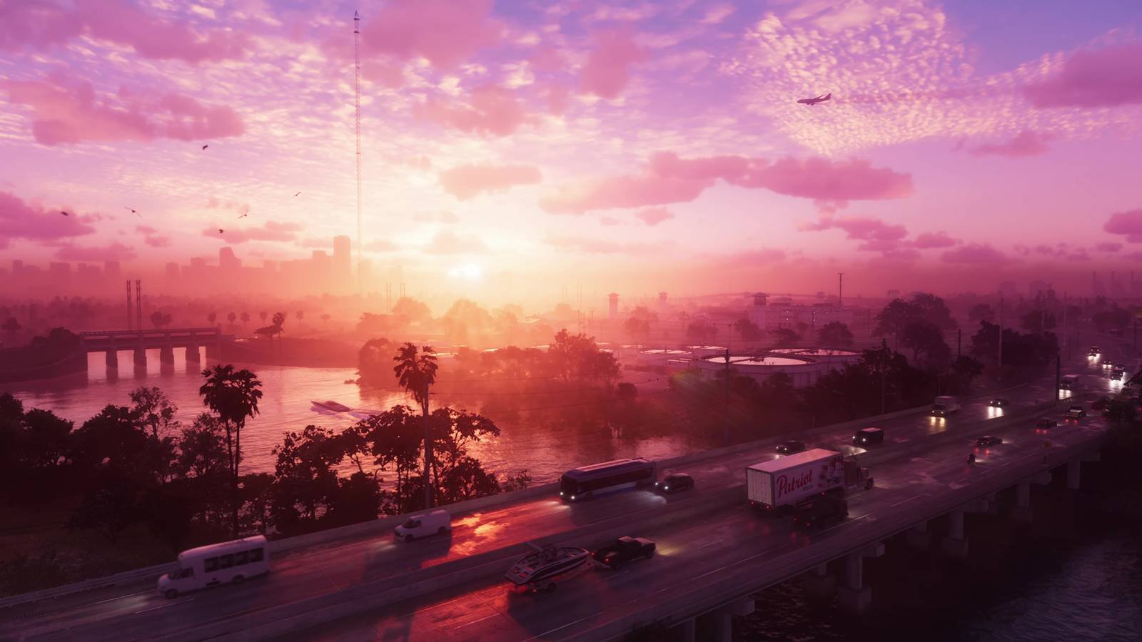 A vibrant pink and orange sunset over a highway bridge in a video game city