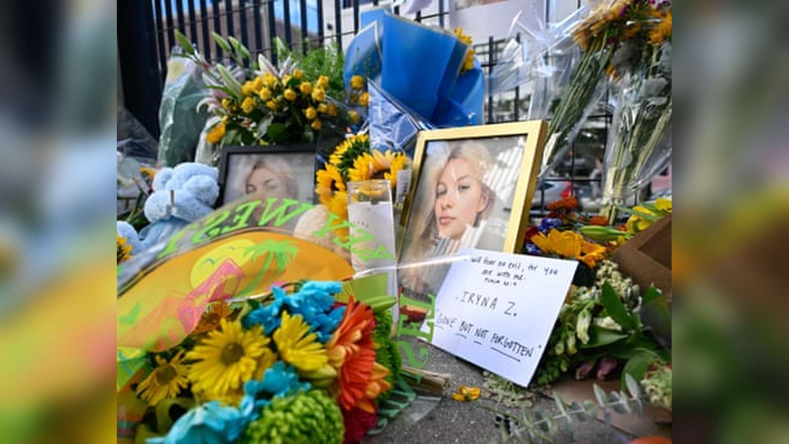 A memorial with flowers, candles, and a framed photograph of Iryna Zarutska