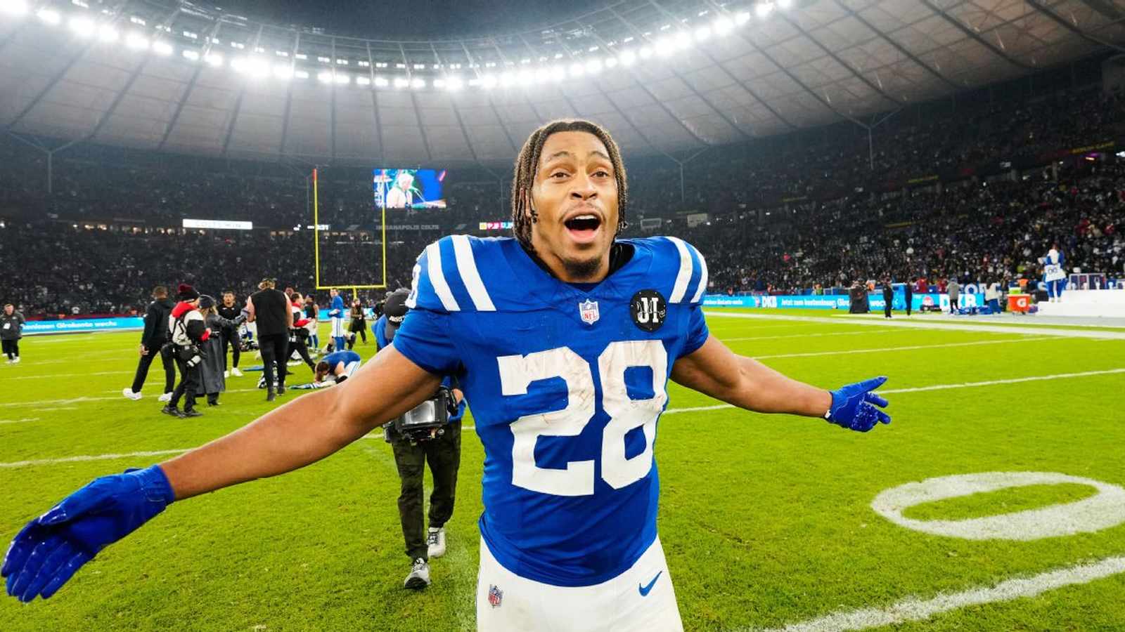 Jonathan Taylor wearing his blue Indianapolis Colts jersey celebrating on the football field