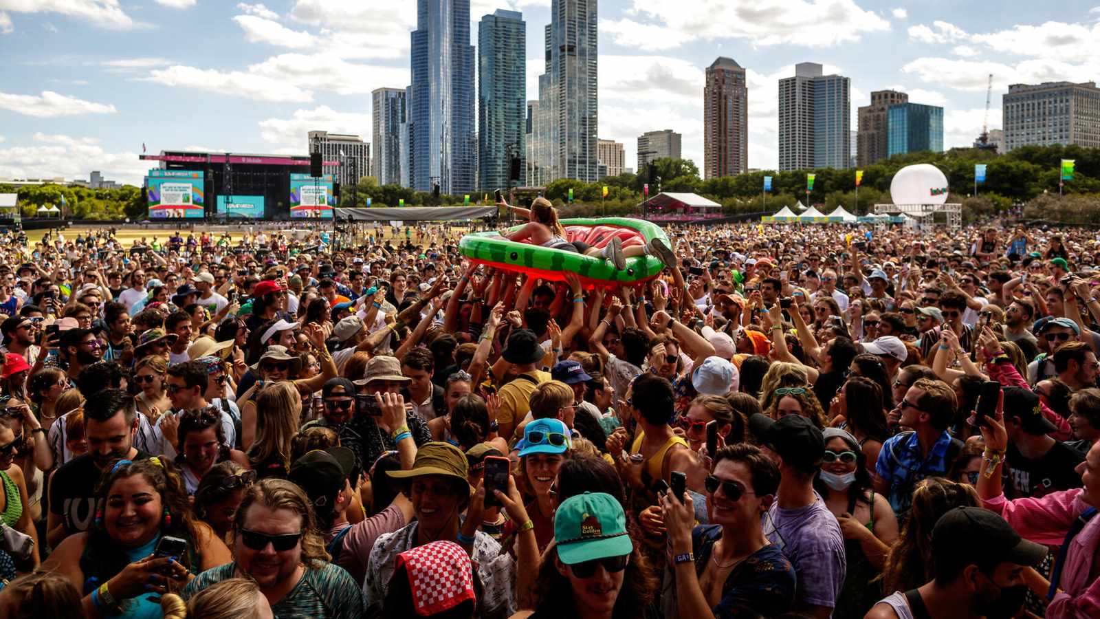 A large crowd at Lollapalooza festival in Chicago with the city skyline behind