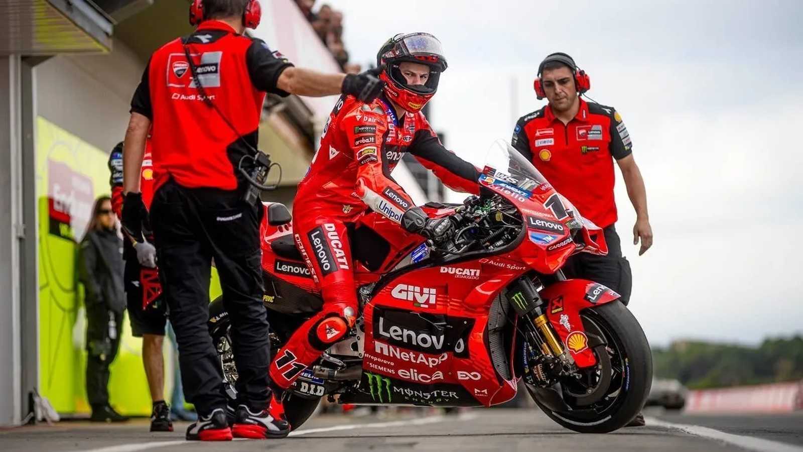 Nicolo Bulega sitting on his red Ducati racing motorcycle in the pit lane