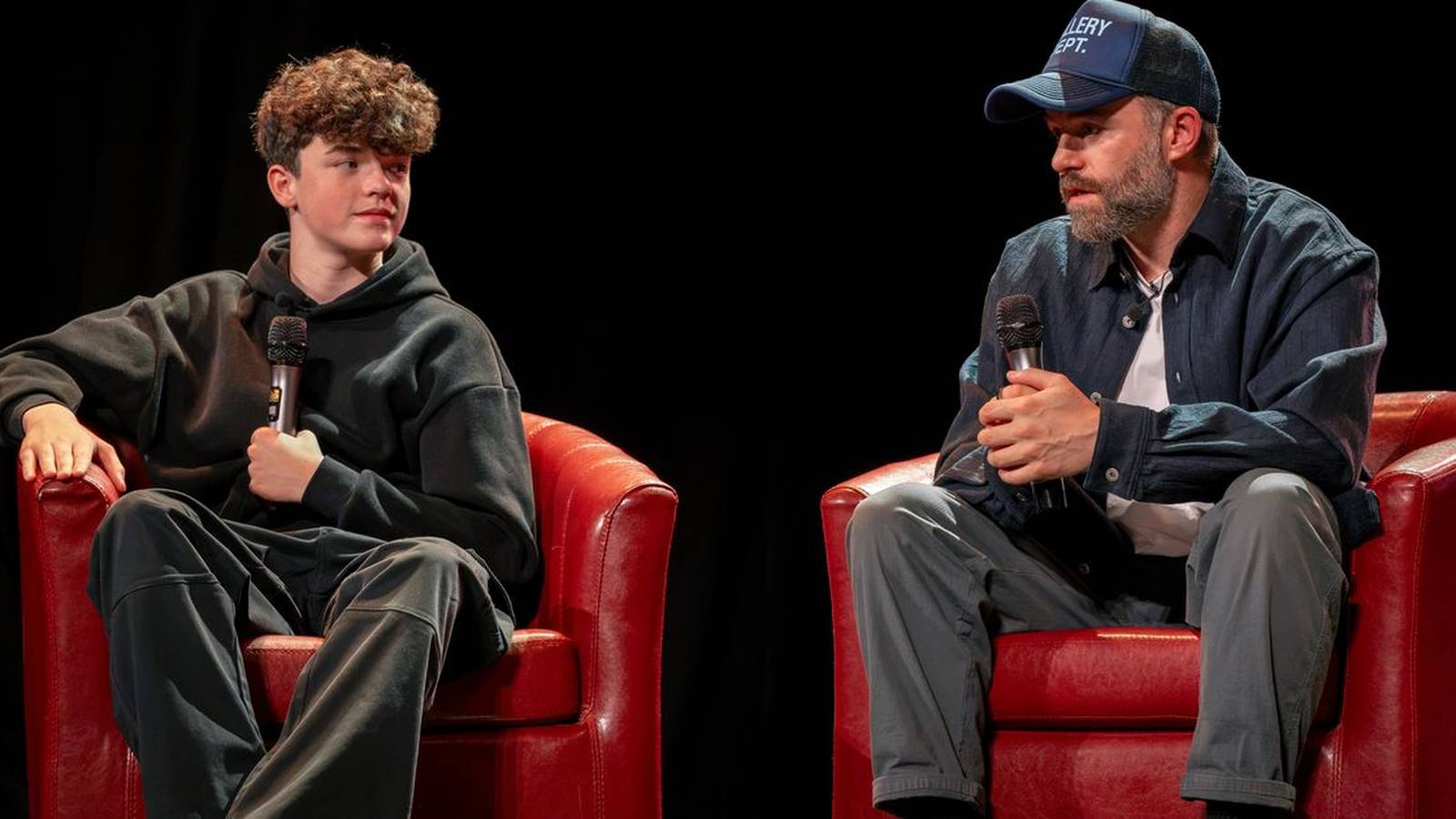 Young actor Owen Cooper sitting in a red chair during a panel discussion
