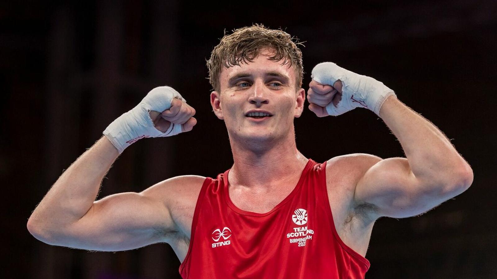 Scottish boxer Sam Hickey celebrating a victory in his red Team Scotland vest
