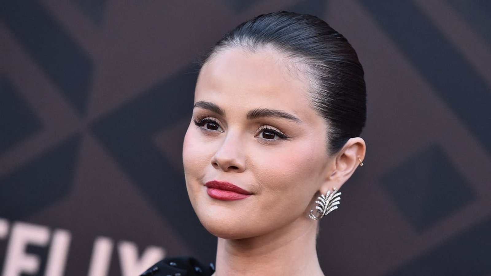 Close up portrait of Selena Gomez with dark hair and elegant earrings