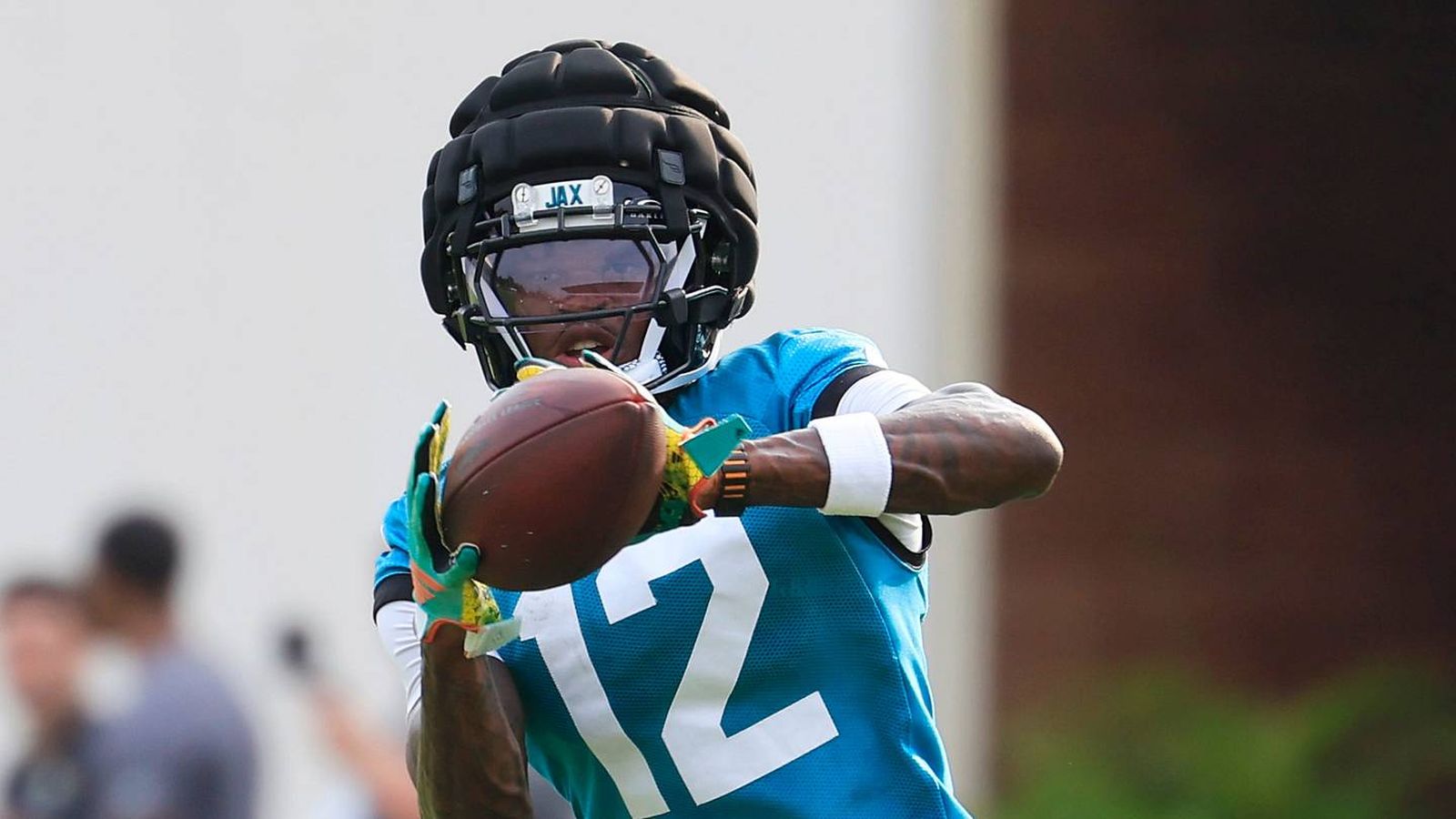 Travis Hunter wearing a Jacksonville Jaguars jersey catching a football during training camp practic
