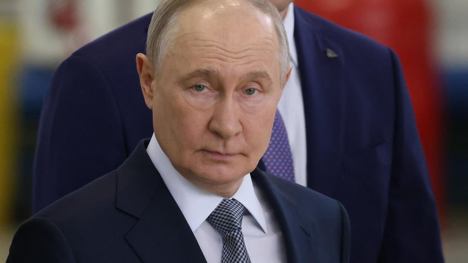 Russian President Vladimir Putin wearing a dark suit and tie looking directly forward