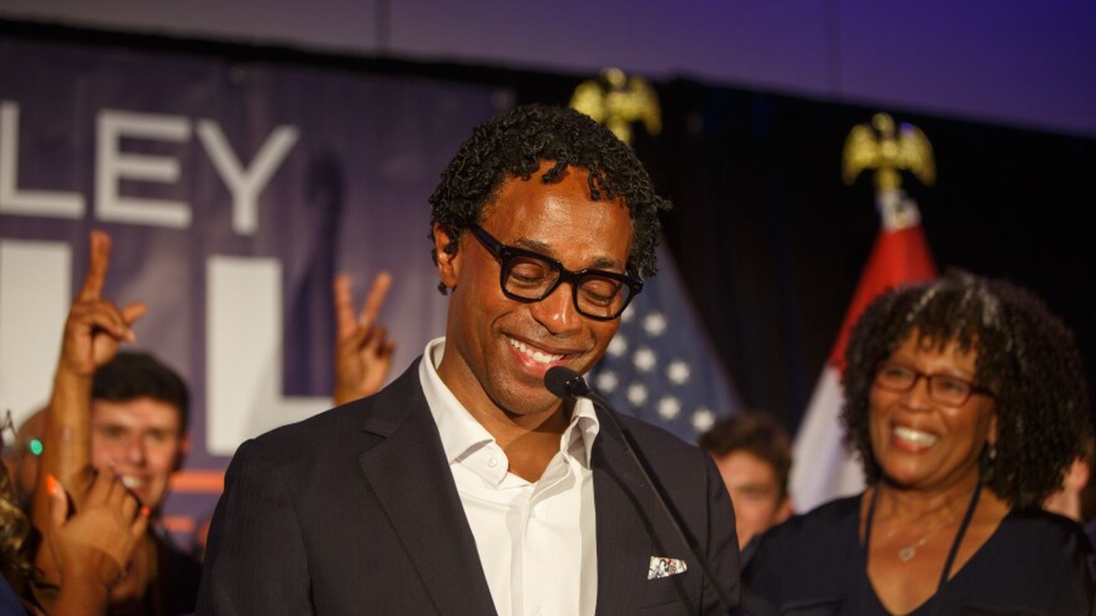 Wesley Bell smiling while speaking at a podium during his primary election victory event