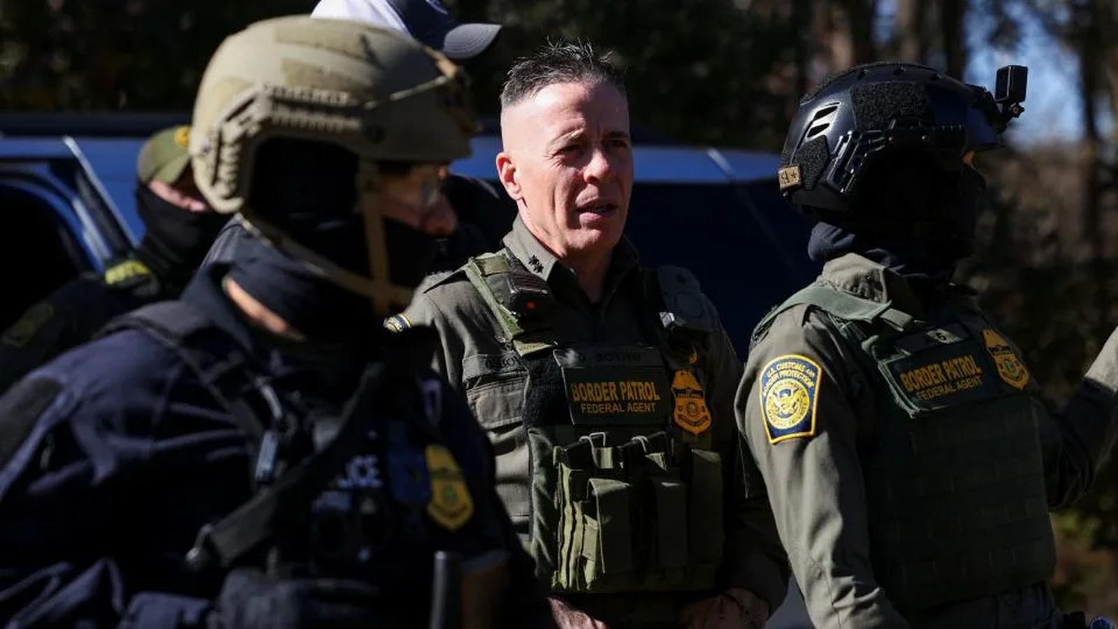 Three US Border Patrol agents in tactical gear standing outdoors during an operation