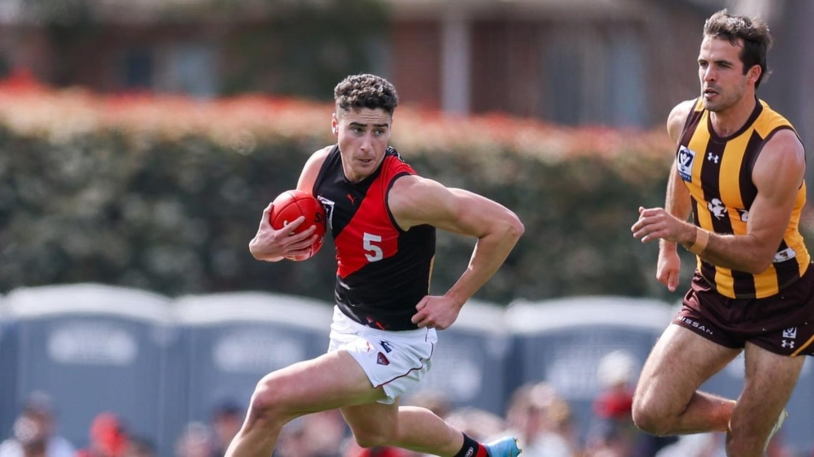 A Box Hill Hawks player chases an Essendon Bombers player during a VFL match