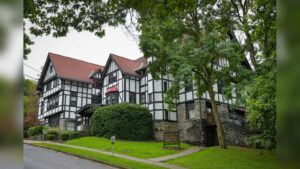 A Tudor-style building with black and white timber framing and red roof on Cornell University campus
