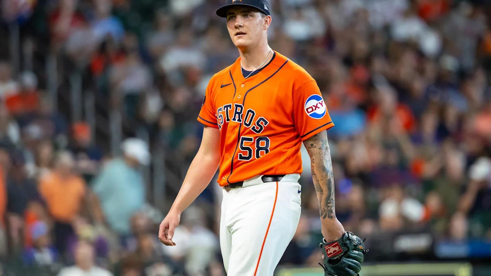 Houston Astros baseball pitcher in an orange jersey walking off the field during a game