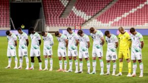 Irish soccer players in white and green uniforms lined up on the pitch