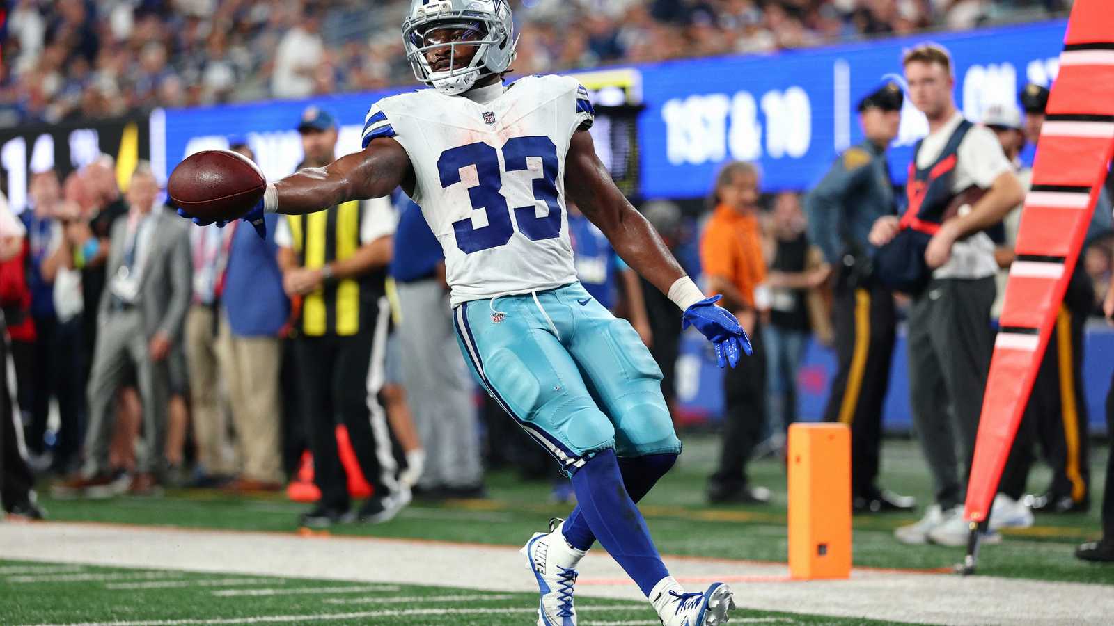 Dallas Cowboys running back Javonte Williams extending the football while running on the field