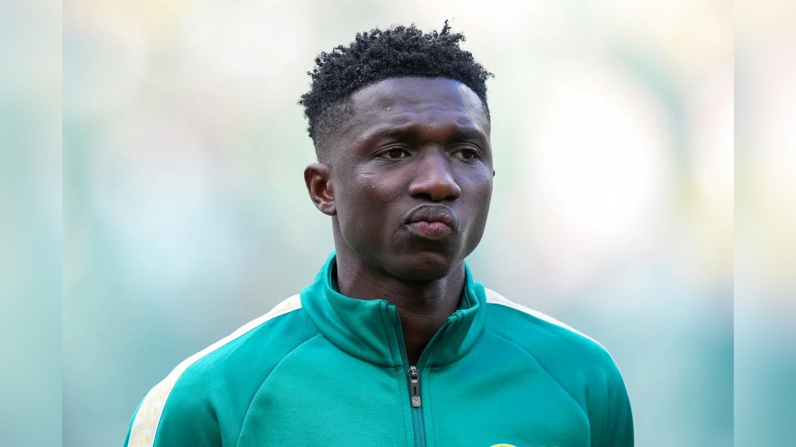 Senegalese footballer Lamine Camara wearing a green training jacket looking towards the camera
