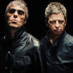 Two men, Liam and Noel Gallagher of Oasis, wearing leather jackets against a black background