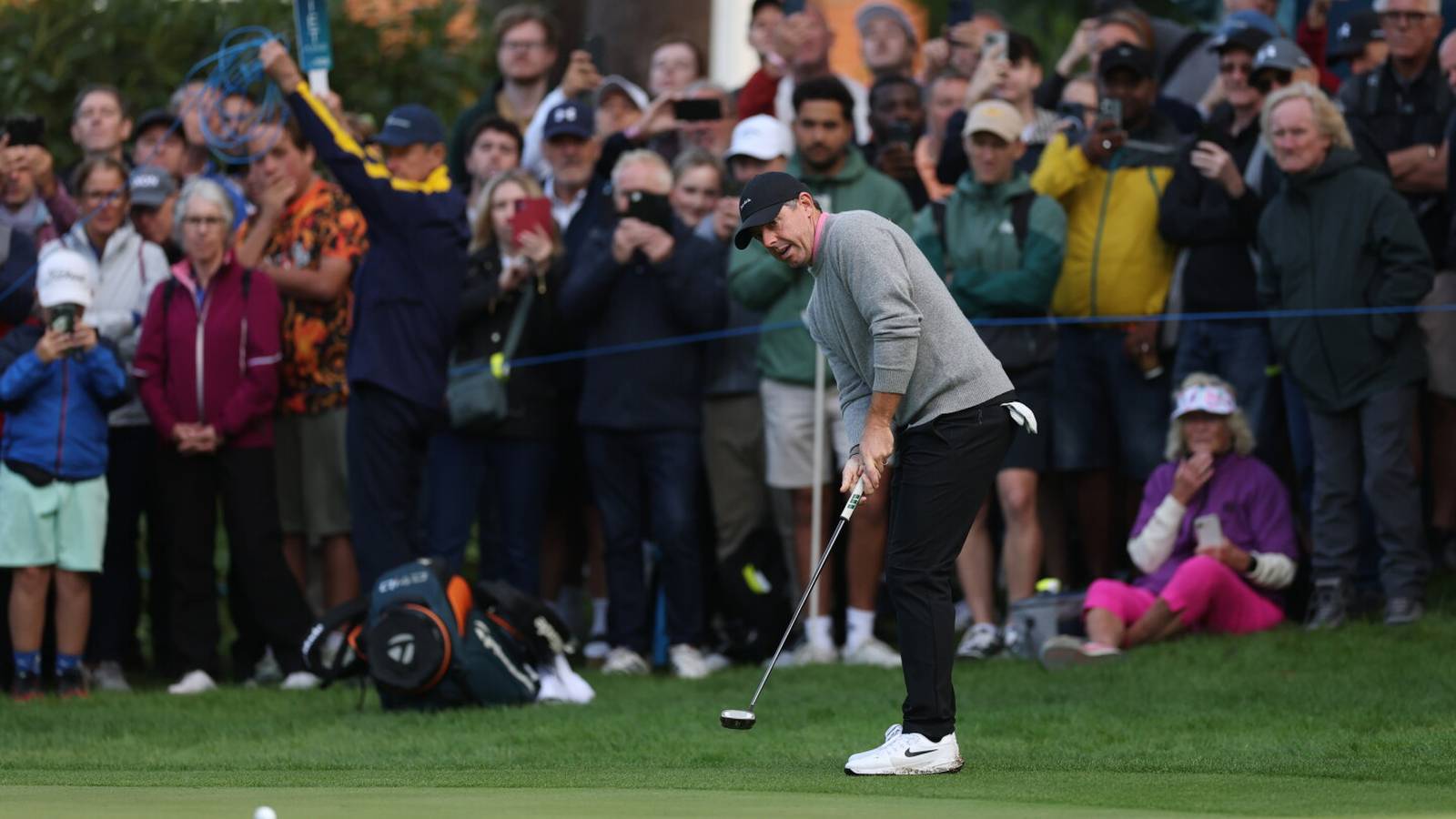 Rory McIlroy focused on a putt at the BMW PGA Championship with spectators watching