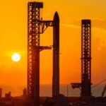 The SpaceX Starship rocket stands on the launch pad at sunrise near the ocean