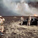 US Marines posing near a burnt car under a smoke-darkened sky in Kuwait, 1991