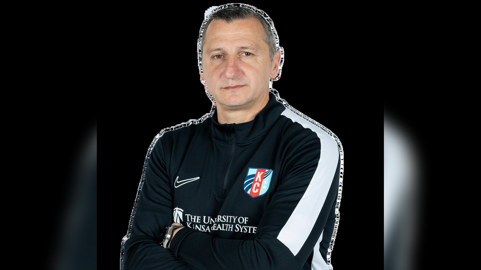Vlatko Andonovski wearing a black KC Current training jacket with arms crossed