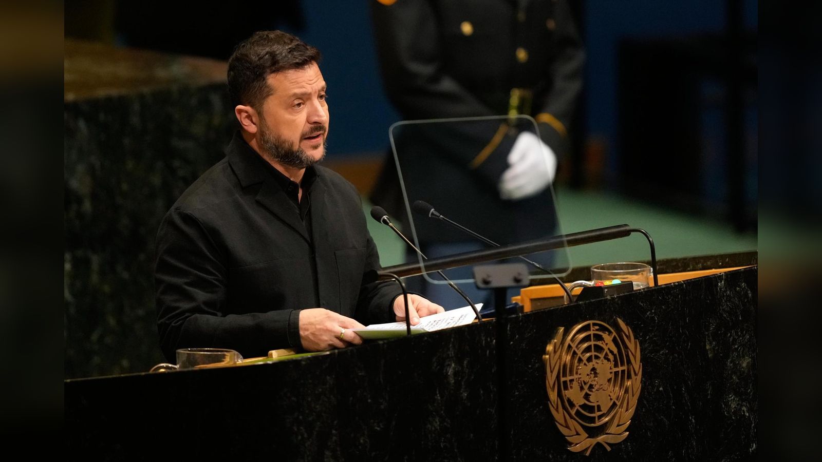 Ukrainian President Volodymyr Zelenskyy speaking at a podium with the United Nations emblem visible