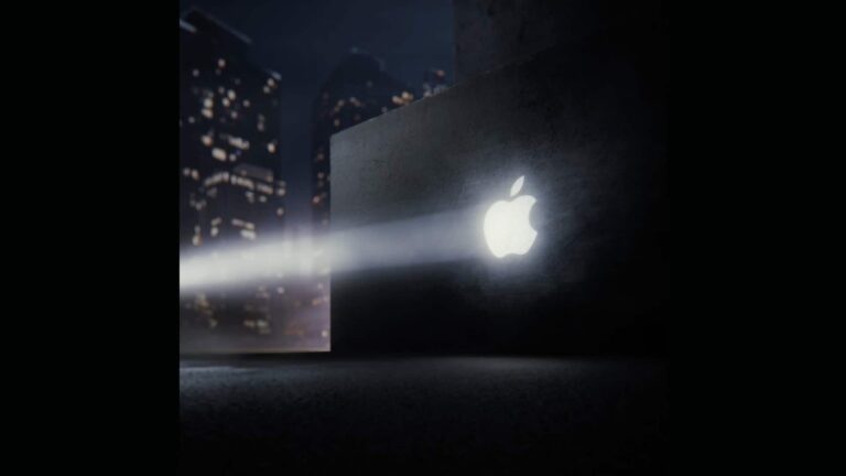 Glowing Apple logo projected on a dark wall with city skyline in background