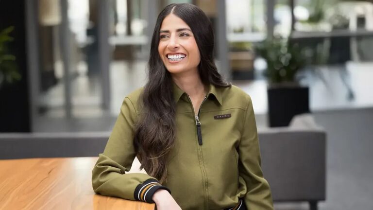 Portrait of Xbox leader Asha Sharma smiling in an office setting wearing an olive green shirt