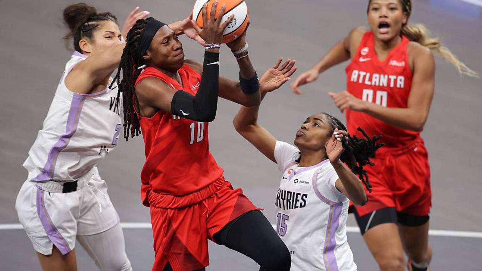 Atlanta Dream basketball players competing intensely during a professional game on the court