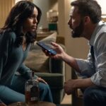 Ben Affleck and co-star in a tense dramatic scene holding a smartphone indoors