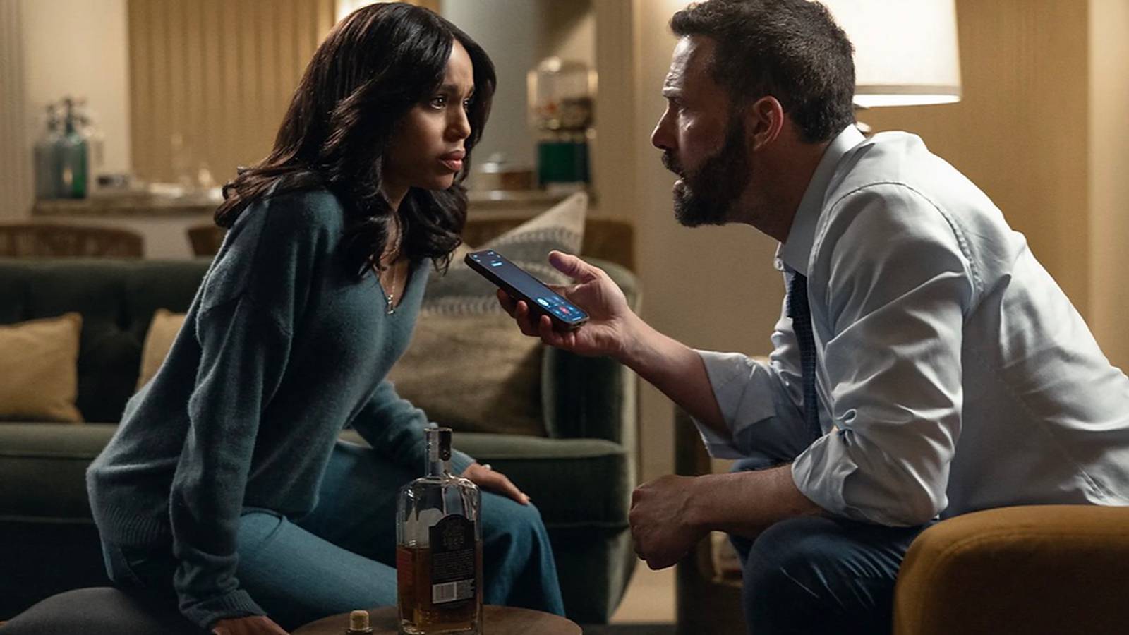 Ben Affleck and co-star in a tense dramatic scene holding a smartphone indoors