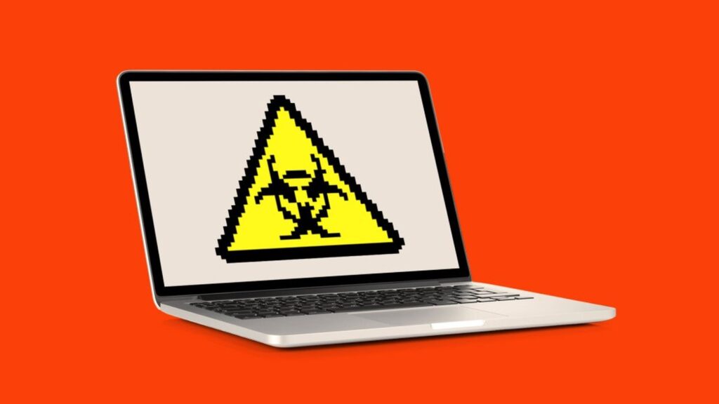 A laptop screen displaying a yellow pixelated biohazard warning symbol against an orange background