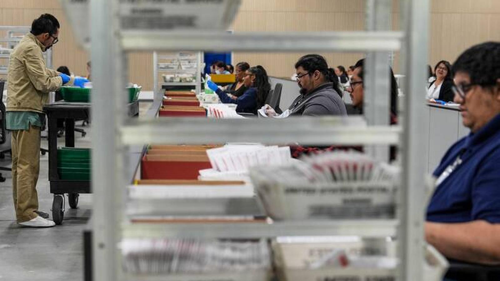 Election workers sorting and processing mail-in ballots at a processing facility
