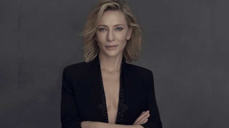 Portrait of actress Cate Blanchett wearing a dark blazer against a grey background