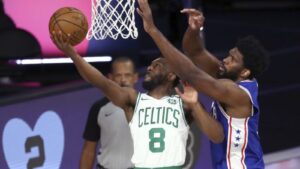Boston Celtics player driving with the basketball against a Philadelphia 76ers defender during a gam