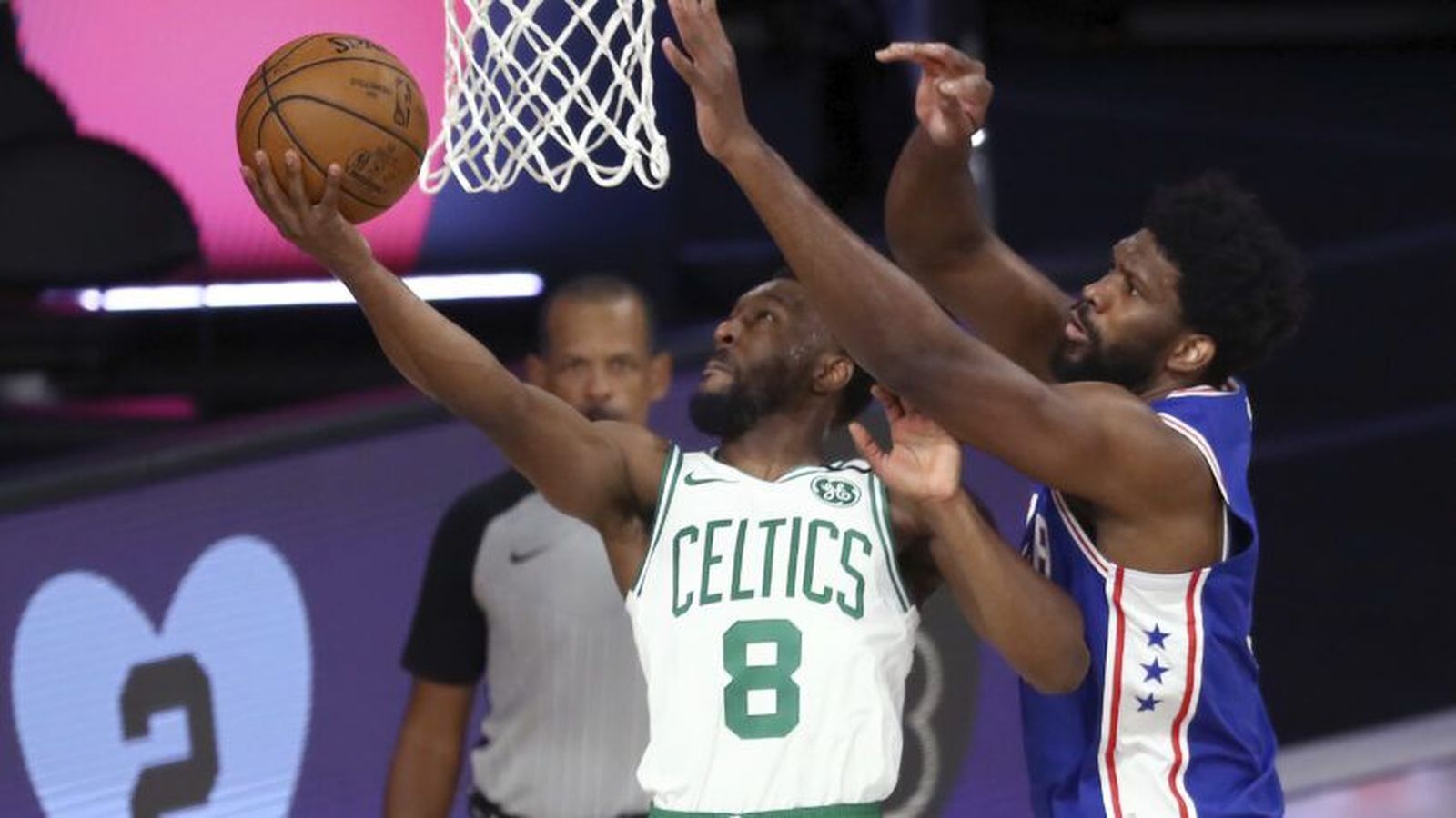 Boston Celtics player driving with the basketball against a Philadelphia 76ers defender during a gam